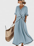 Front view of dress showing v-neckline with contrast trim and twist waist cinch
