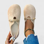 Beige rope strap loafers viewed from the side on white background