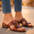 Woman sitting wearing mule sandals, feet visible at angle