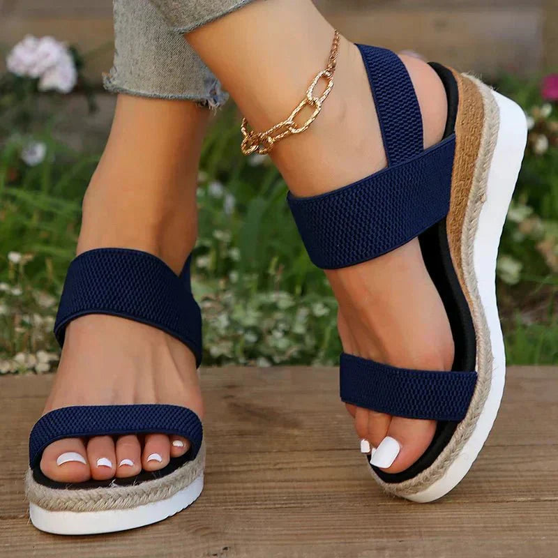 Model seated wearing stretch strap platform sandals, lifestyle shot