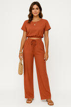 Model wearing crop top and wide leg trousers set, standing pose