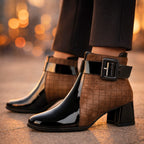 Black patent leather ankle boots with brown quilted side panels and oversized buckle detail