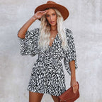 Woman wearing animal print V-neck romper with wide leg shorts, front view