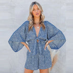 Back view of woman in animal print romper displaying neckline and fit