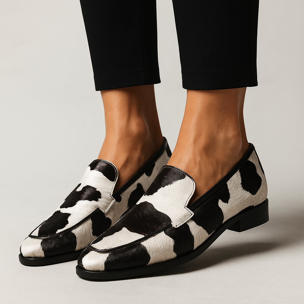 Woman wearing cow print loafers with pointed toe, styled for work