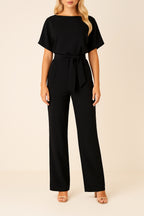 Woman wearing black belted wide leg jumpsuit, front view, full length