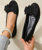Black ballet flats with bow accent, front view