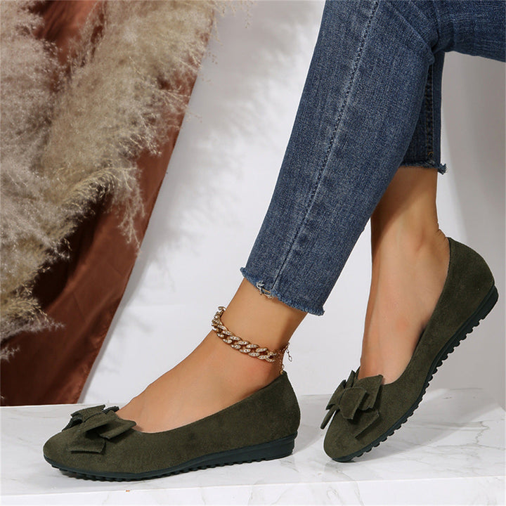Woman walking in black bow ballet flats