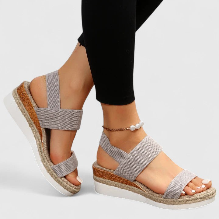 Woman sitting and wearing black platform sandals, relaxed pose