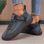 Black leather trainer displayed from above showing lace detail