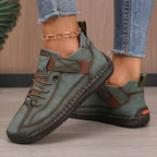 Full-length view of woman in black leather trainers from front angle