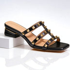 Black leather studded mule sandal with gold pyramid studs and block heel, front view