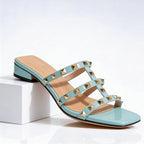 Close-up of gold-tone pyramid studs on triple cage straps