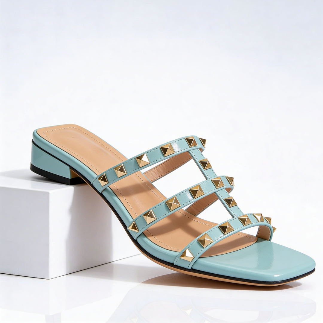 Close-up of gold-tone pyramid studs on triple cage straps