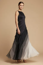 Woman wearing black ombre maxi dress, side pose showing asymmetric layered skirt