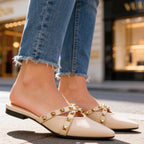 Woman wearing mules with leg extended, showcasing pointed toe