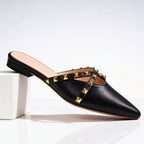 Side view of studded mule showing pointed toe silhouette and low-profile sole