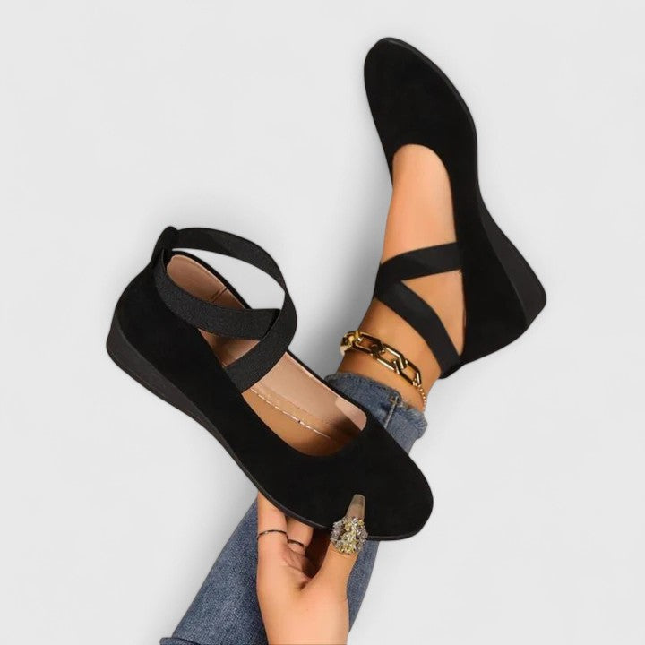 Black suede ballet flats with elasticated cross straps, front view