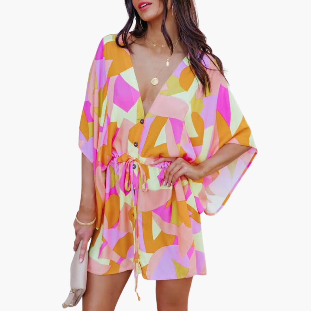 Model wearing tropical leaf dress, standing pose showing flowing sleeves and fitted waist