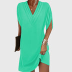 Back view of black mini dress with split hem detail