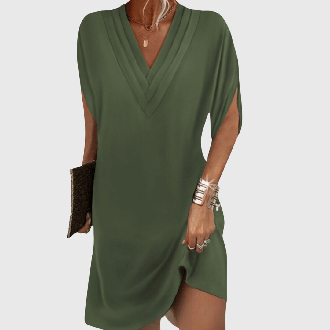Model wearing black mini dress, side profile showing draping