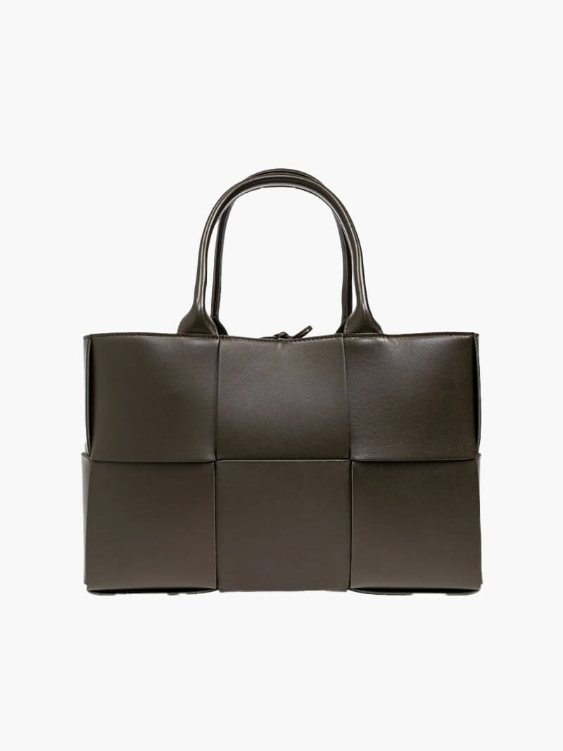 Woven tote bag worn over shoulder, styled for everyday wear
