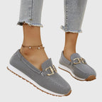 Close-up of gold-tone horsebit detail on denim upper
