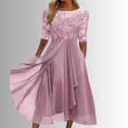 Model posing in lace midi dress showing side profile and draping