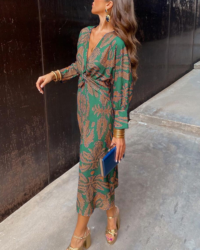 Model wearing paisley dress showing V-neckline and waist knot styling from front