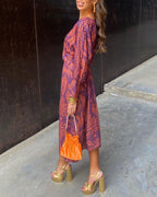 Back view of flowing A-line maxi dress with long sleeves and paisley pattern