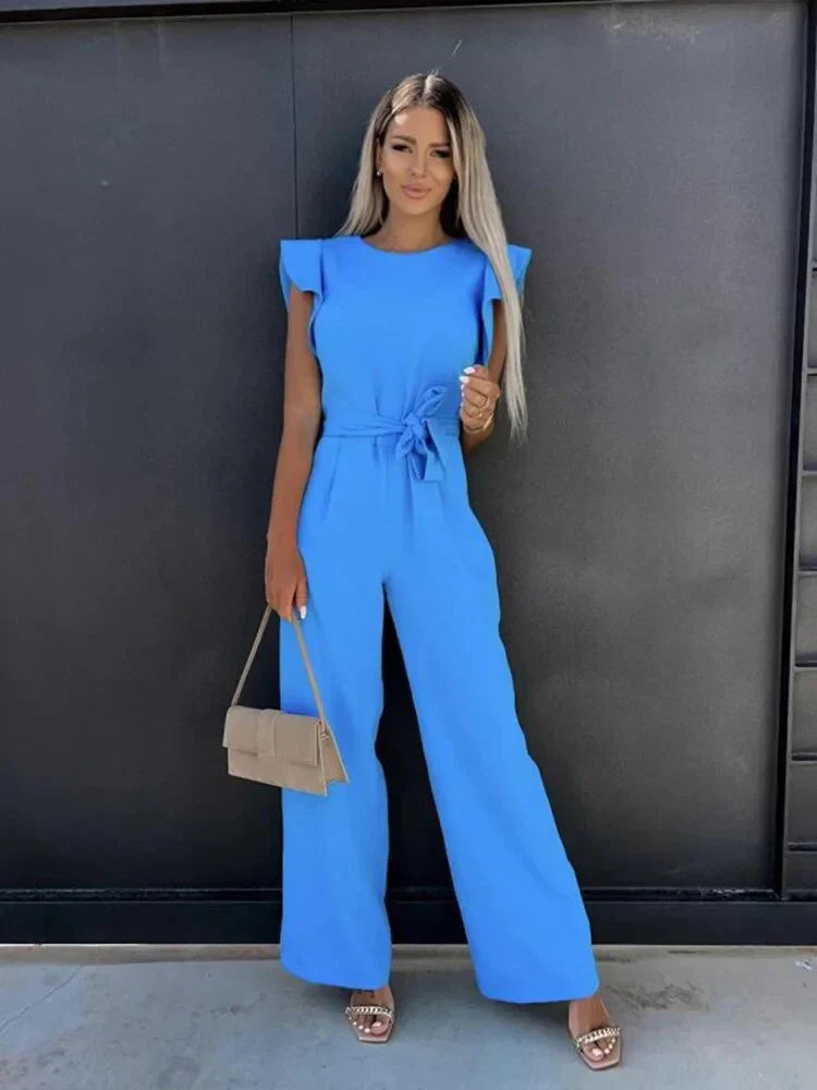 Model wearing blue jumpsuit, full length pose showing wide leg silhouette