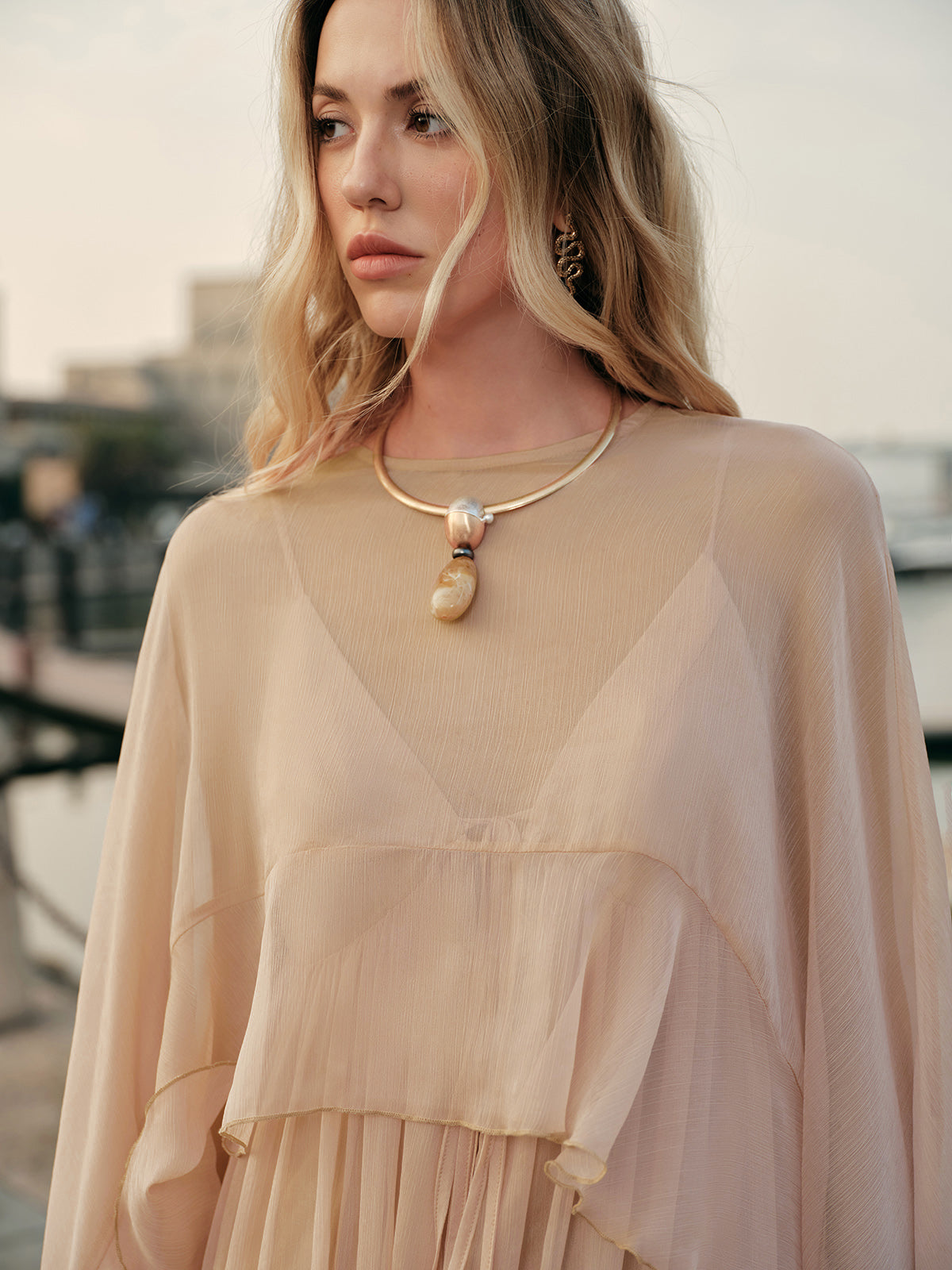 Side profile highlighting dramatic cloak sleeve design