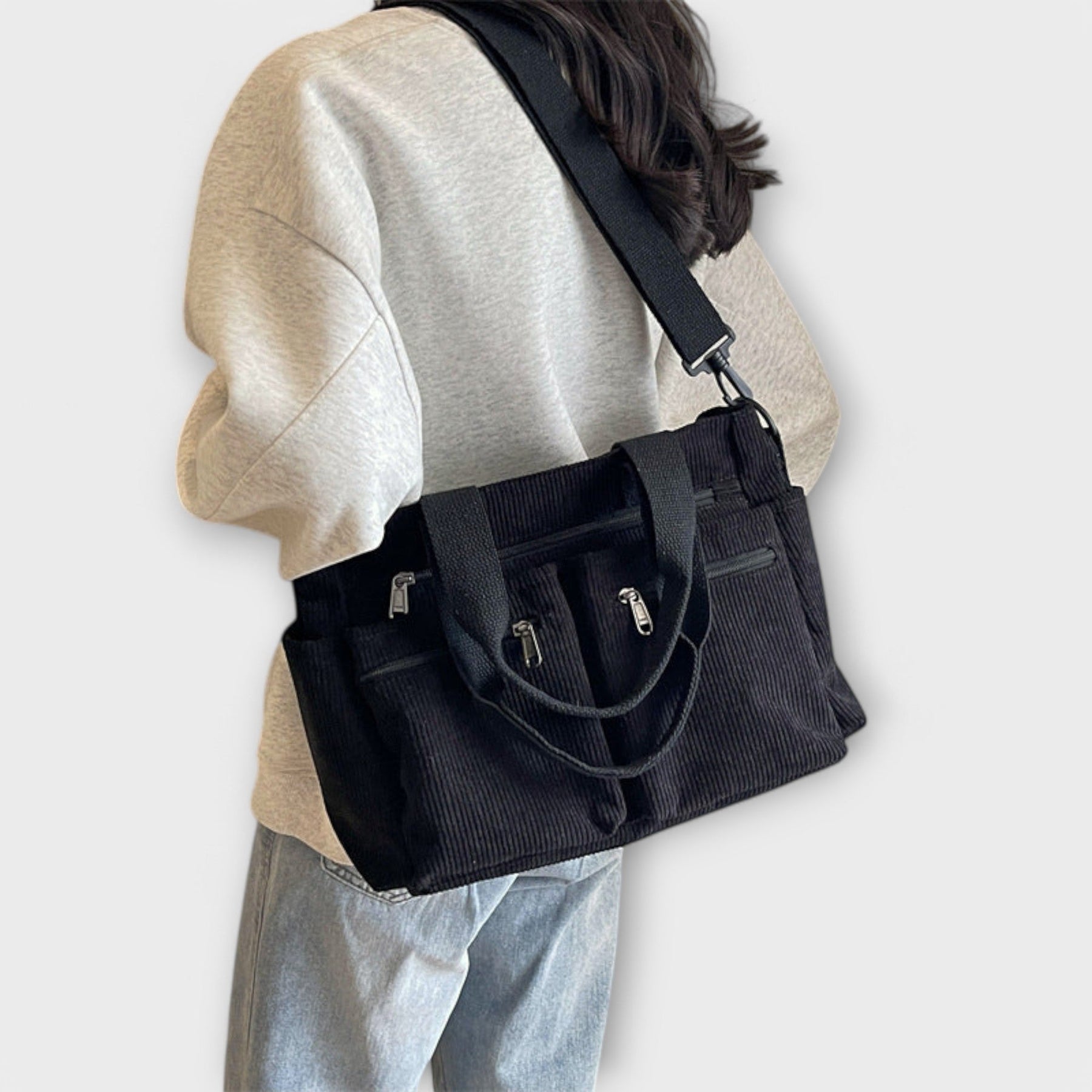 Model holding corduroy tote with both hands