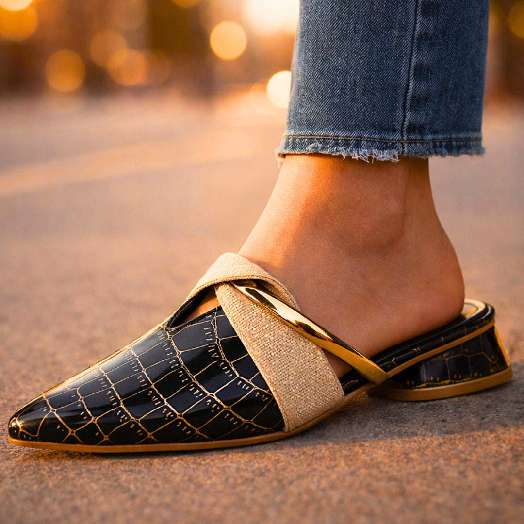 Mule worn on foot, showing pointed toe and open-back design