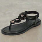 Model wearing pair of embellished sandals, walking shot on pavement