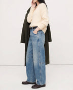 Leopard print jeans draped over seated figure, thigh detail