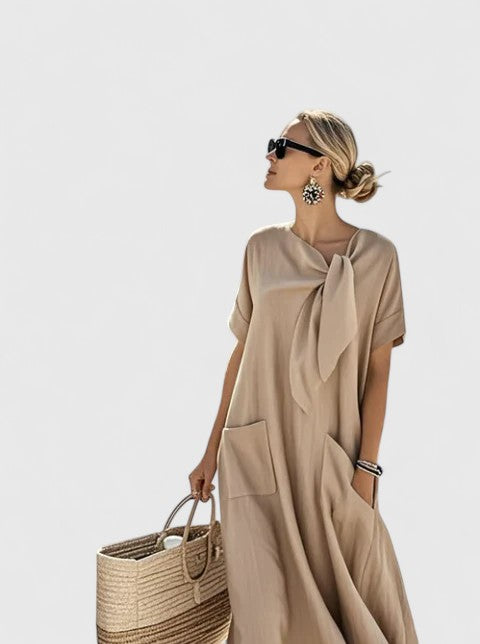 Model in brown maxi dress showing pocket detail and drape