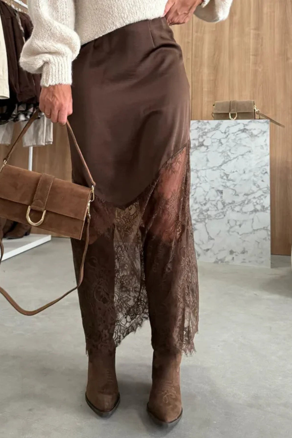Model posing in asymmetric maxi skirt showing side silhouette