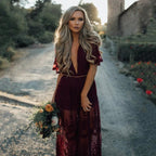 Model in burgundy lace maxi dress, movement shot showing flowing skirt