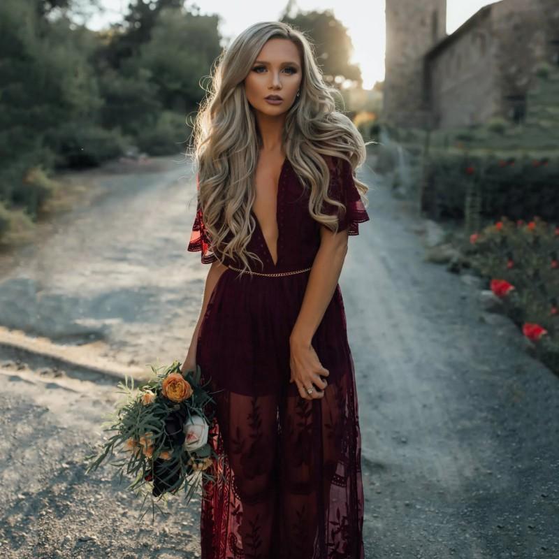 Model in burgundy lace maxi dress, movement shot showing flowing skirt