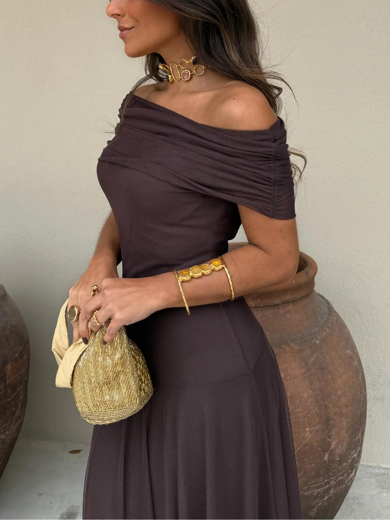 Model posing in chocolate brown maxi dress, three-quarter view