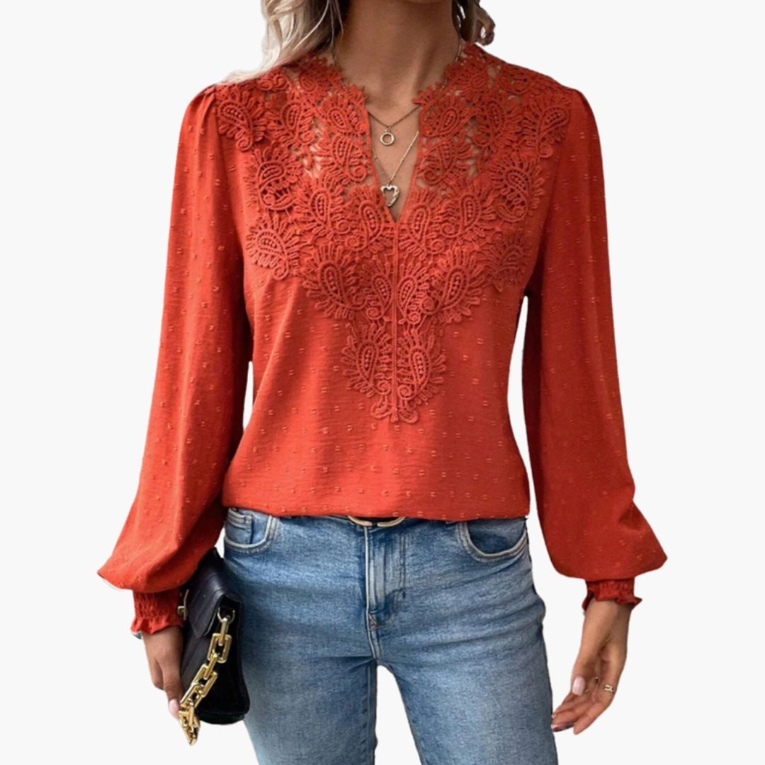 Woman wearing coral red lace trim V-neck blouse, front view