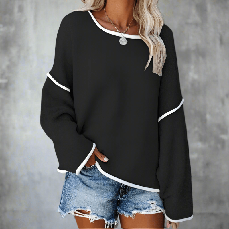 Model wearing off-shoulder jumper, relaxed pose showing drape and fit
