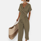 Model wearing jumpsuit with draped wrap front, side angle