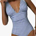 Model wearing striped swimsuit, side profile showing shoulder strap and fit