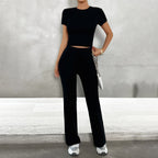 Model wearing set seated, showing relaxed fit of wide leg trousers