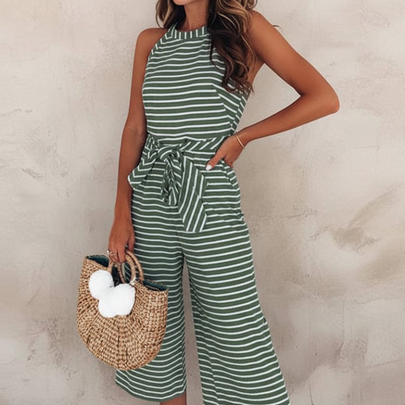 Full-length shot of woman posing in striped jumpsuit with belt fastened at waist