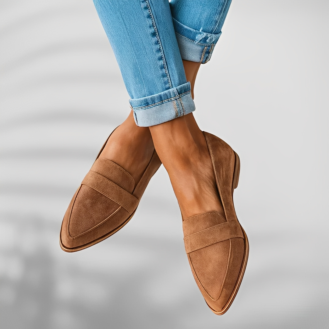 Woman wearing grey suede loafers with tailored trousers, side view