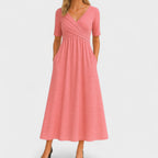 Model wearing dress in three-quarter turn showing elbow sleeve and silhouette