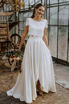 Model wearing ivory lace crop top and high-low skirt, standing pose
